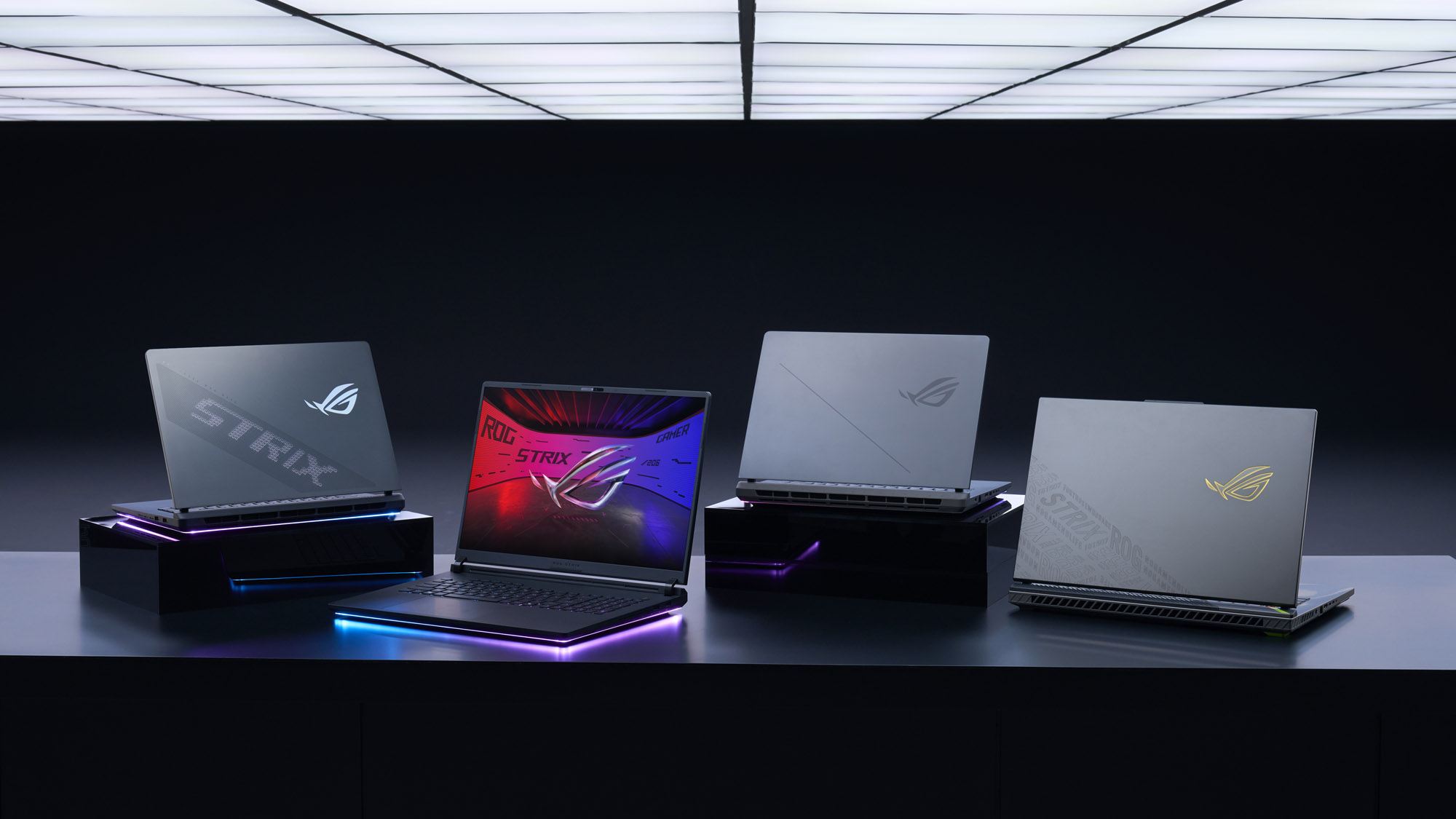 The 2025 Strix laptop lineup on a table in a dark room.
