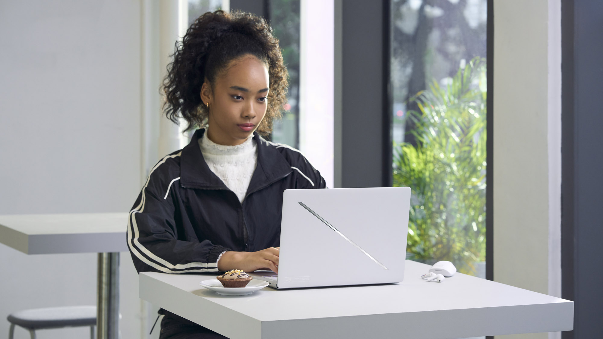 A woman using the Zephyrus G14 on a white table.