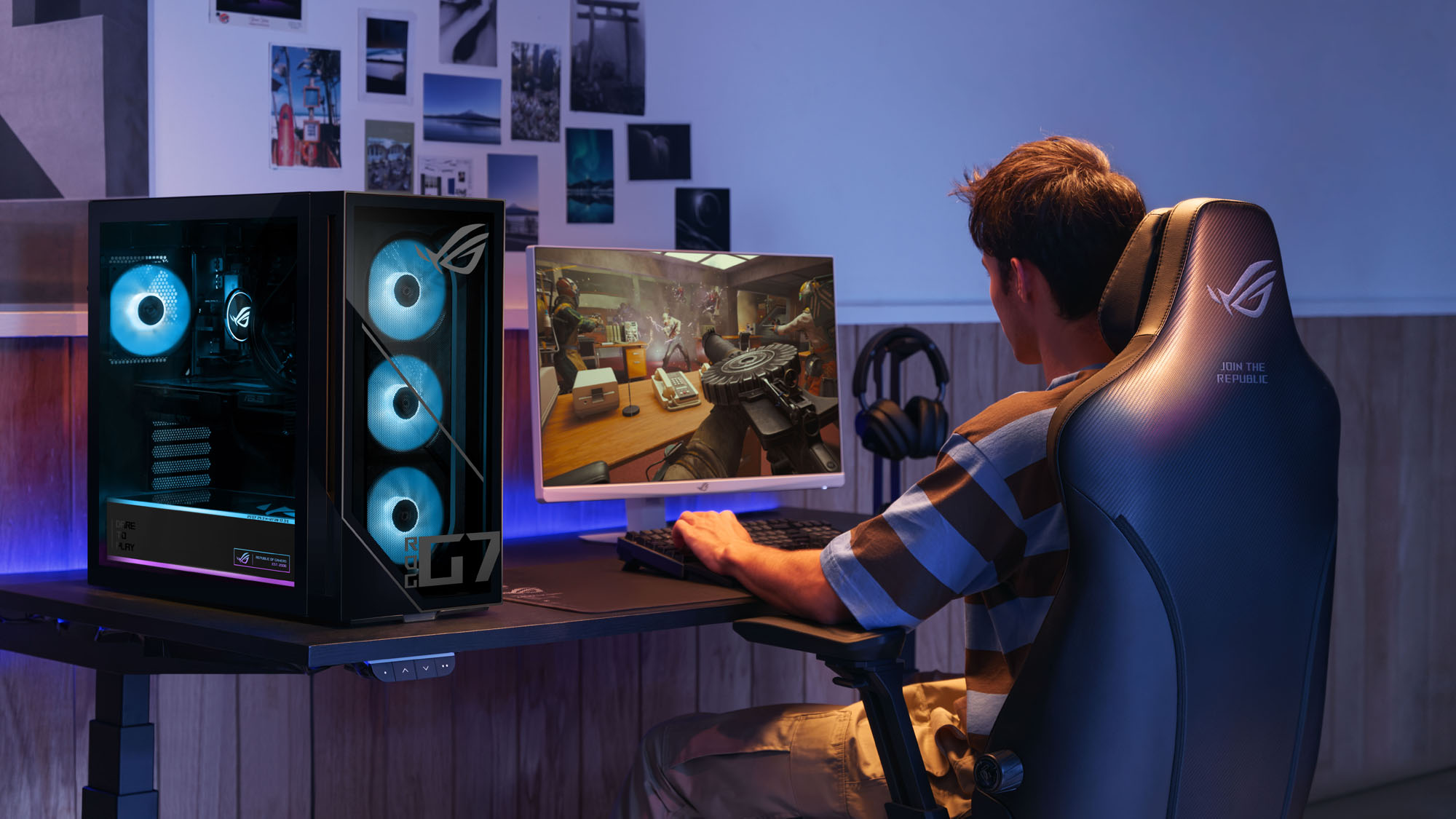 A man playing video games at a desk with an ROG G700 PC